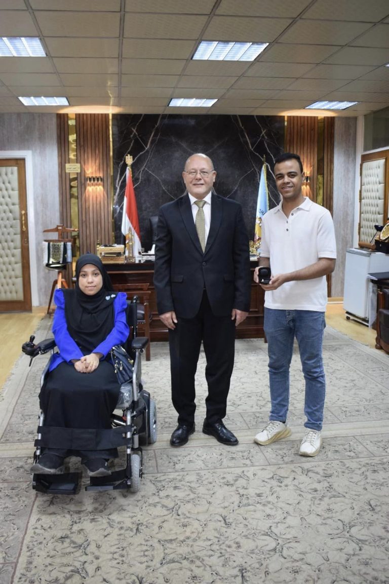*جامعة سوهاج تهدي طالبة وطالب من ذوي الهمم كرسي متحرك كهربائي وسماعتي أذن*